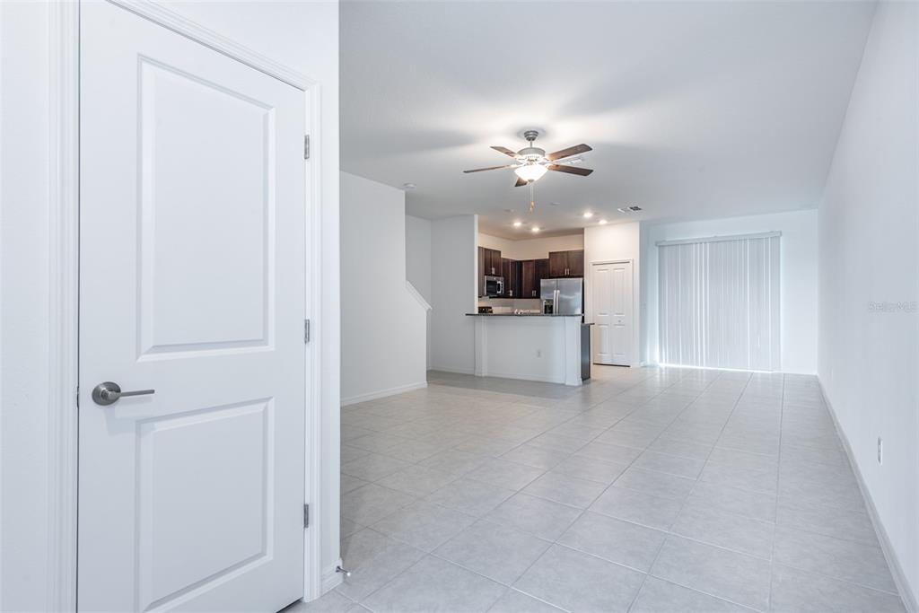 14348 Editors Note Street Ruskin, FL 33573 - Photo 2 of 24 an empty room with a kitchen and a ceiling fan
