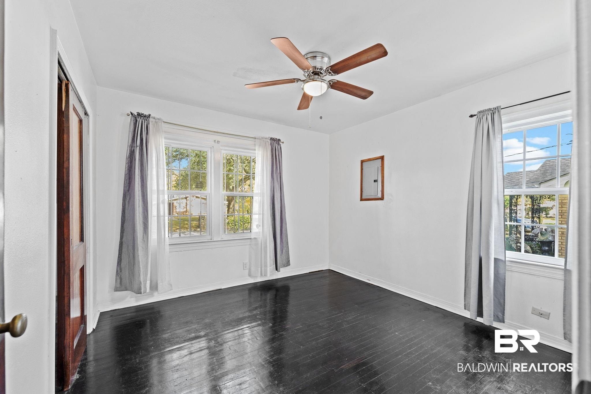 1665 Johnston Street Mobile, AL 36605 - Photo 10 of 17 Spare room featuring dark hardwood / wood-style flooring, a wealth of natural light, and ceiling fan