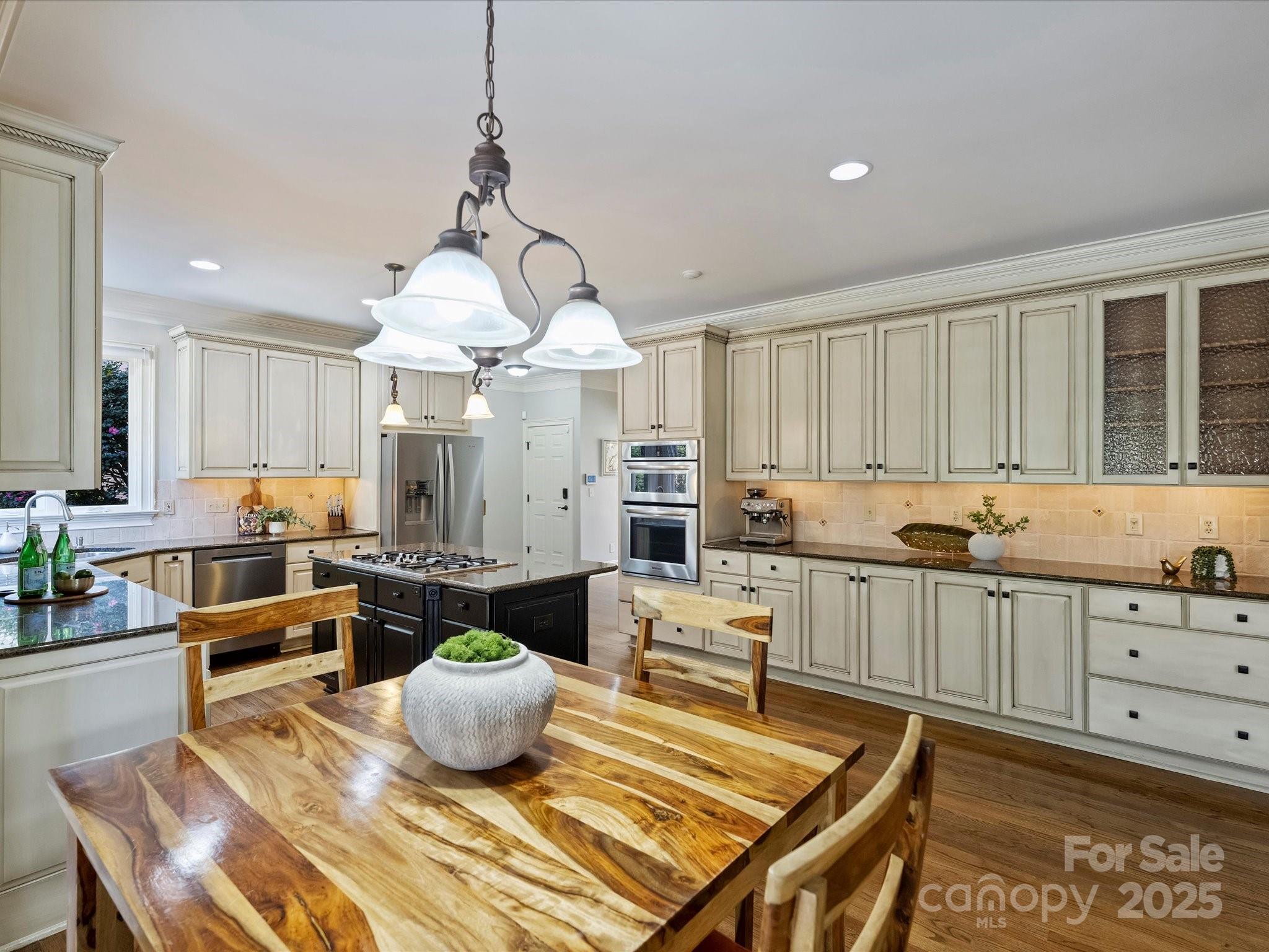 1738 Bardstown Road Charlotte, NC 28226 - Photo 16 of 40 a kitchen with stainless steel appliances granite countertop a stove a sink a dining table and chairs