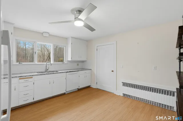 a spacious bathroom with a granite countertop sink and a mirror