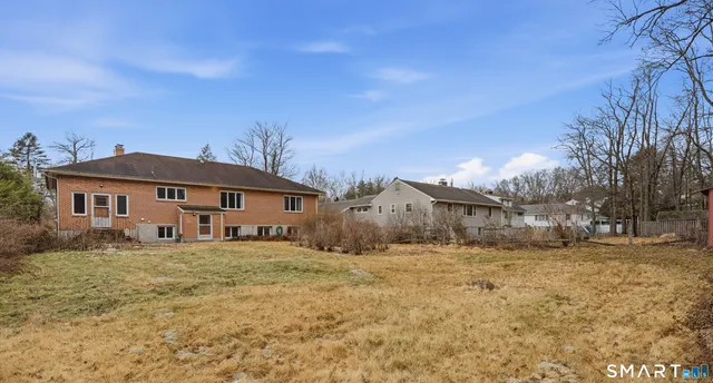 a yellow house sitting in middle of the middle of a yard