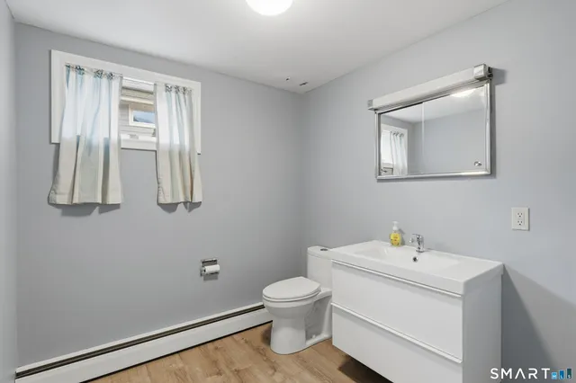 a bathroom with a sink a toilet and a window