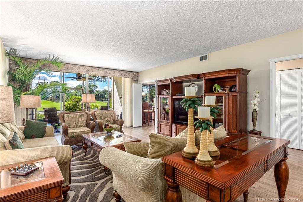 12431 Harbour Ridge Boulevard, Unit 31 Palm City, FL 34990 - Photo 2 of 12 a living room with furniture and a floor to ceiling window