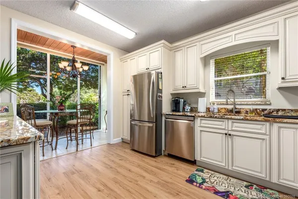 a kitchen with stainless steel appliances granite countertop a refrigerator a stove a sink and a microwave