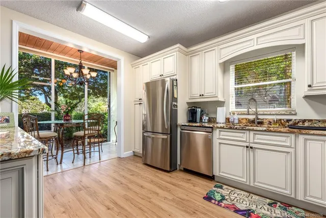 a kitchen with stainless steel appliances granite countertop a refrigerator a stove a sink and a microwave