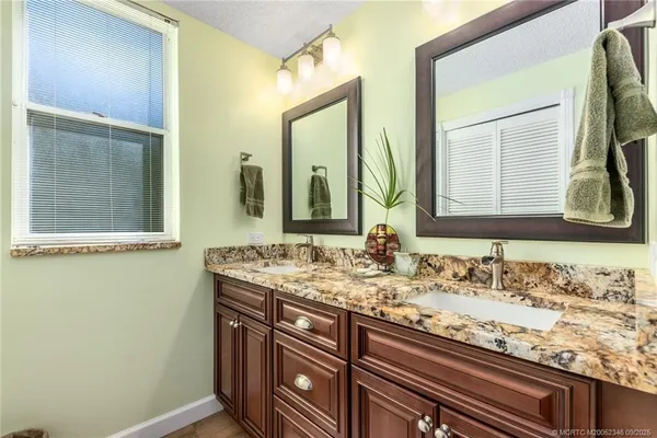a bathroom with a granite countertop sink and a mirror
