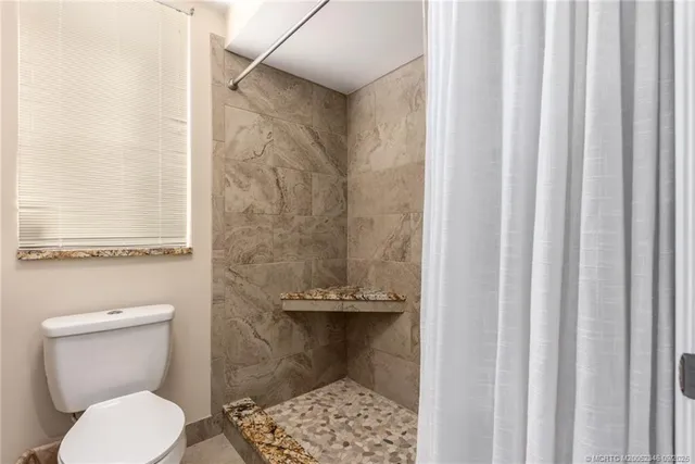 a bathroom with a toilet and a shower