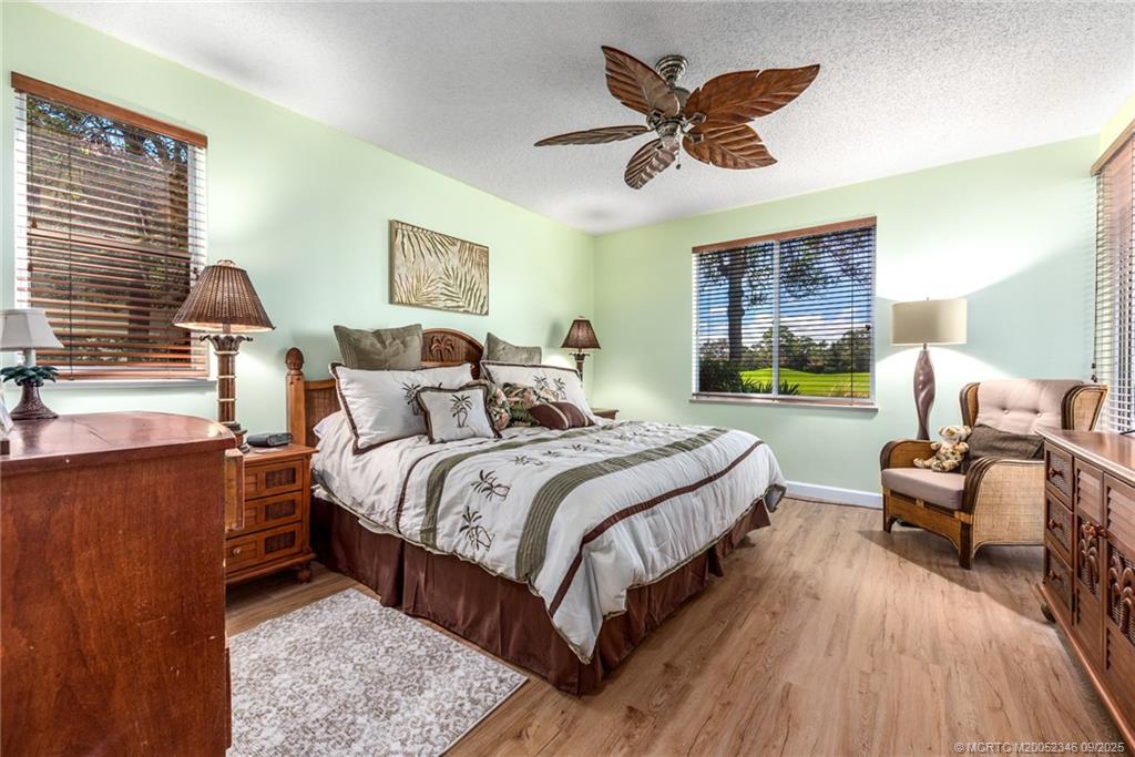 12431 Harbour Ridge Boulevard, Unit 31 Palm City, FL 34990 - Photo 10 of 12 a spacious bedroom with a bed and wooden floor