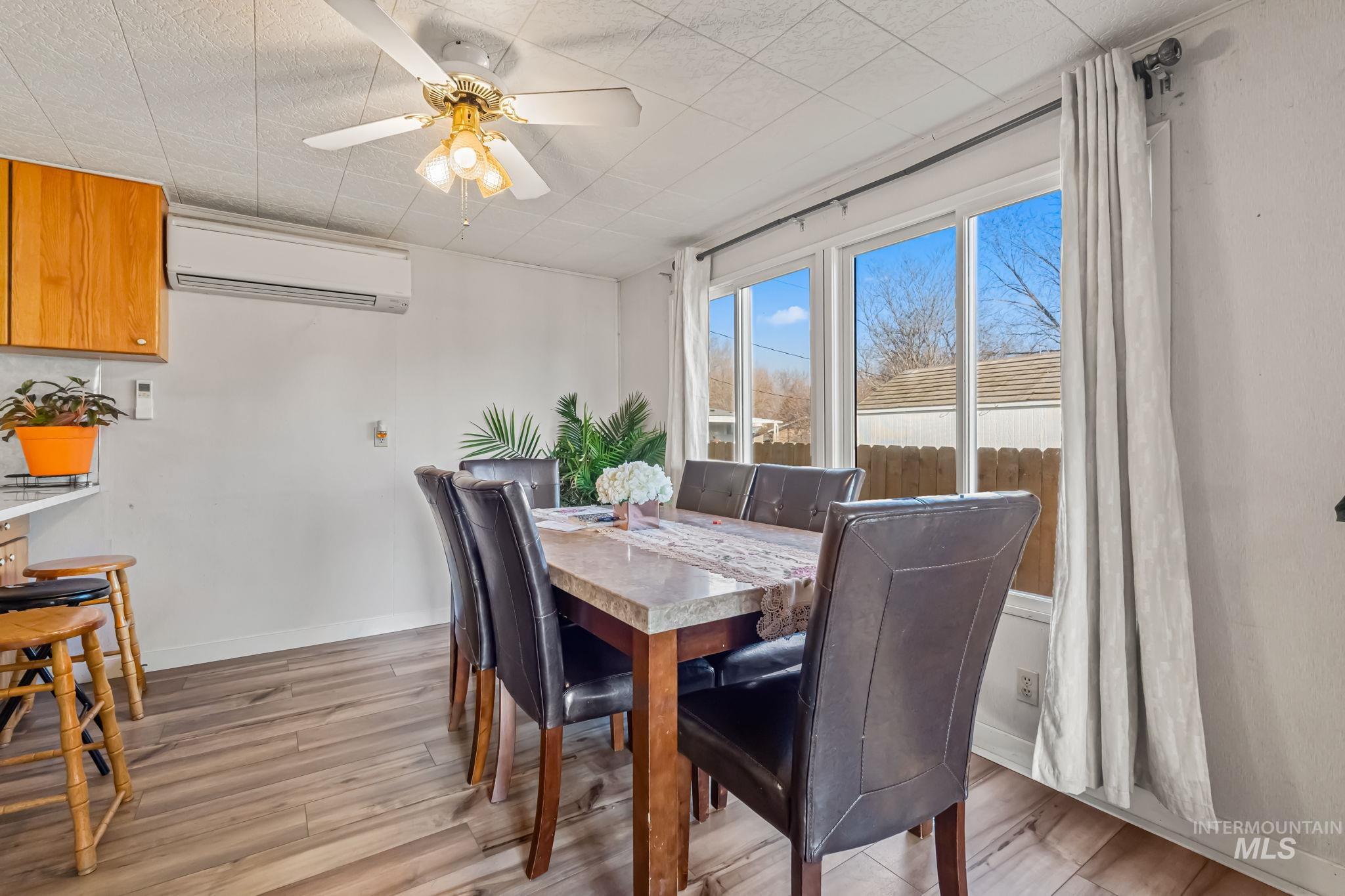 11234 George Street Nampa, ID 83651 - Photo 12 of 25 Dining room with light wood-style floors, an AC wall unit, and a ceiling fan
