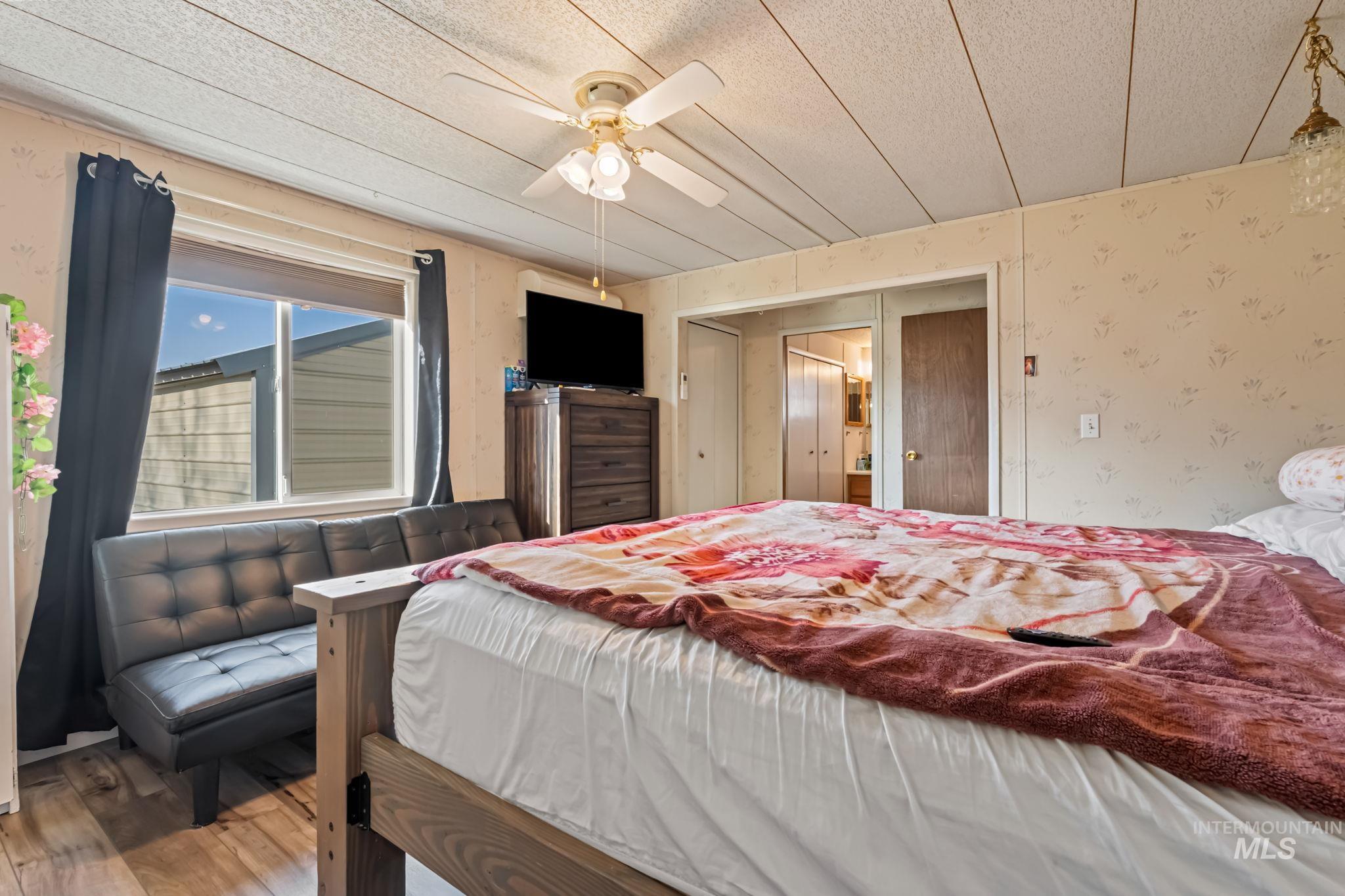 11234 George Street Nampa, ID 83651 - Photo 18 of 25 Bedroom featuring wallpapered walls, hardwood / wood-style floors, a closet, and ceiling fan