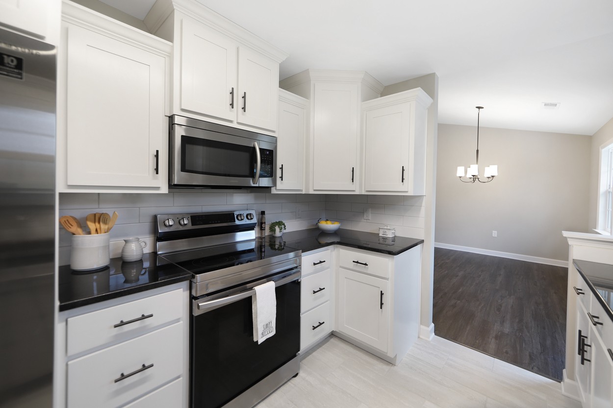 25 Riadon Road Hartsville, TN 37074 - Photo 7 of 19 a kitchen with stainless steel appliances granite countertop a sink a stove a microwave and cabinets