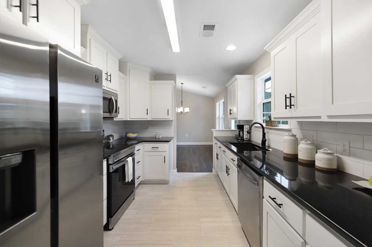 25 Riadon Road Hartsville, TN 37074 - Photo 8 of 19 a kitchen with stainless steel appliances granite countertop a sink a stove and a refrigerator
