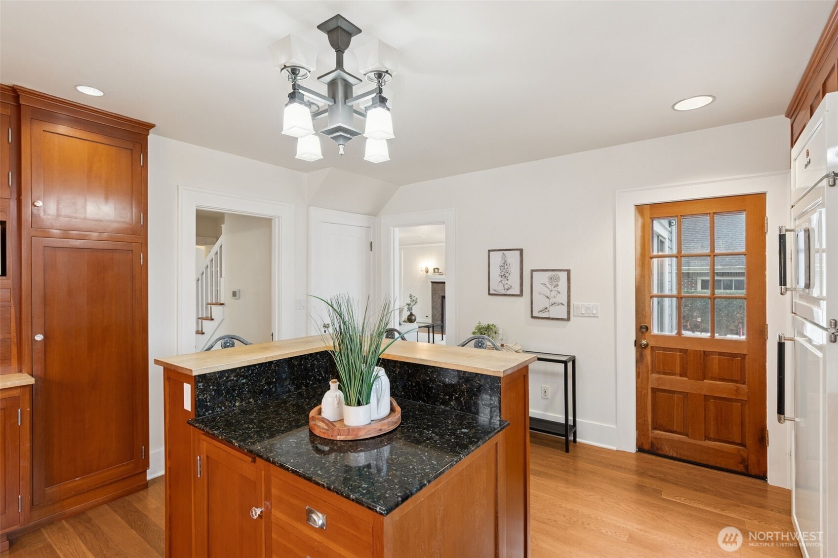 2305 Columbia Street Southwest Olympia, WA 98501 - Photo 7 of 34 a dining room with wooden floor a chandelier a wooden table and chairs