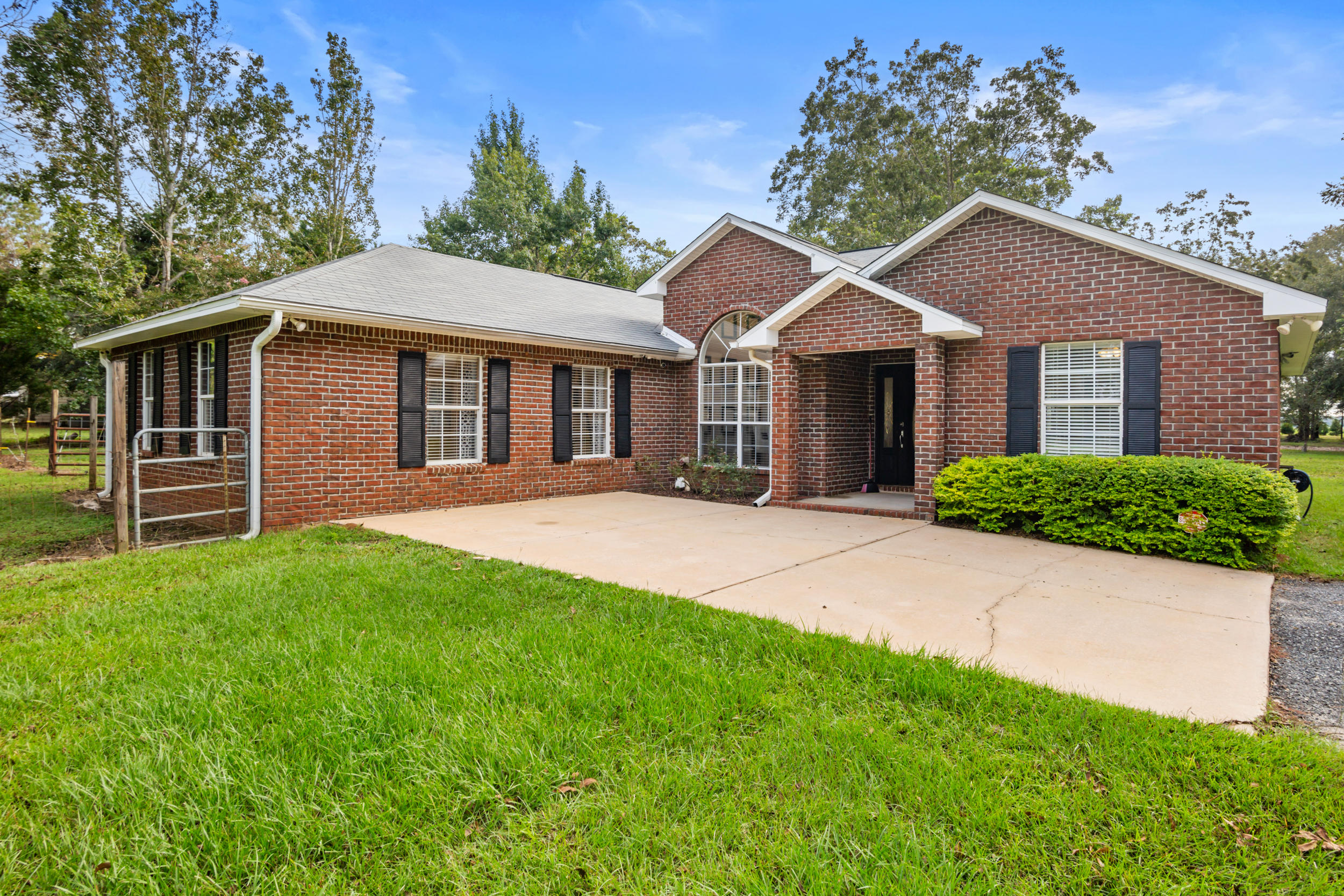 5975 Jack Stokes Road Baker, FL 32531 - Photo 2 of 44 a front view of a house with a garden