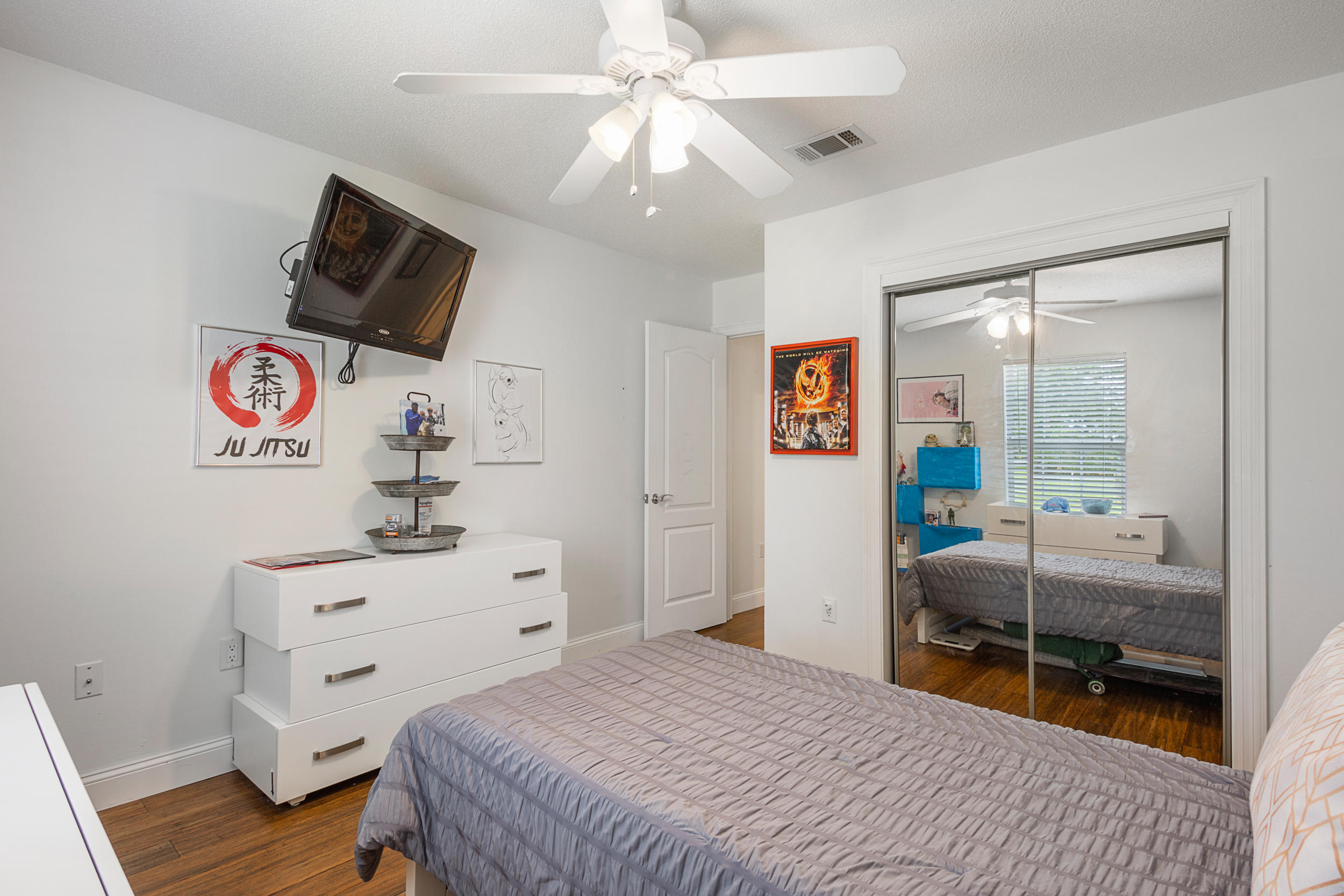 5975 Jack Stokes Road Baker, FL 32531 - Photo 19 of 44 a bedroom with a bed and wooden floor
