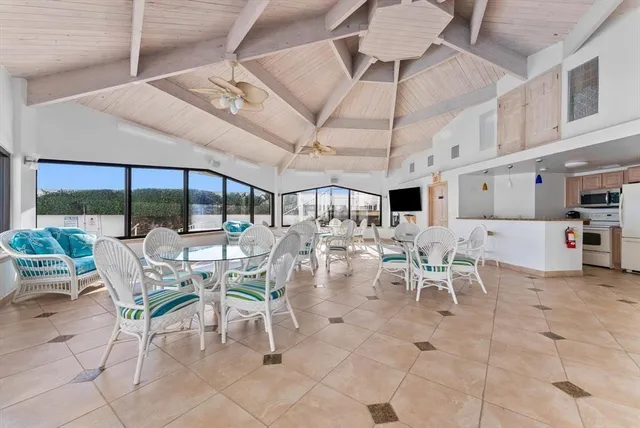 a view of a dining room with furniture a kitchen and chandelier