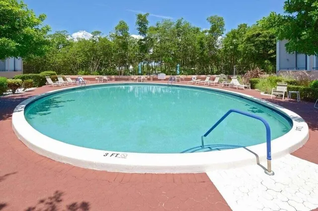 a view of a swimming pool with a yard and sitting area
