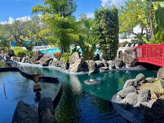 a backyard of a house with lots of green space and fountain