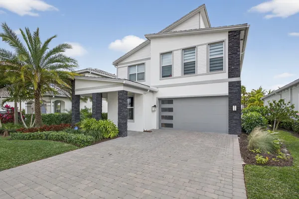 a front view of a house with a garden and garage