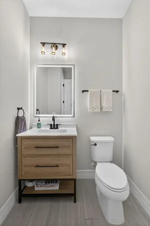 a bathroom with a sink mirror and toilet