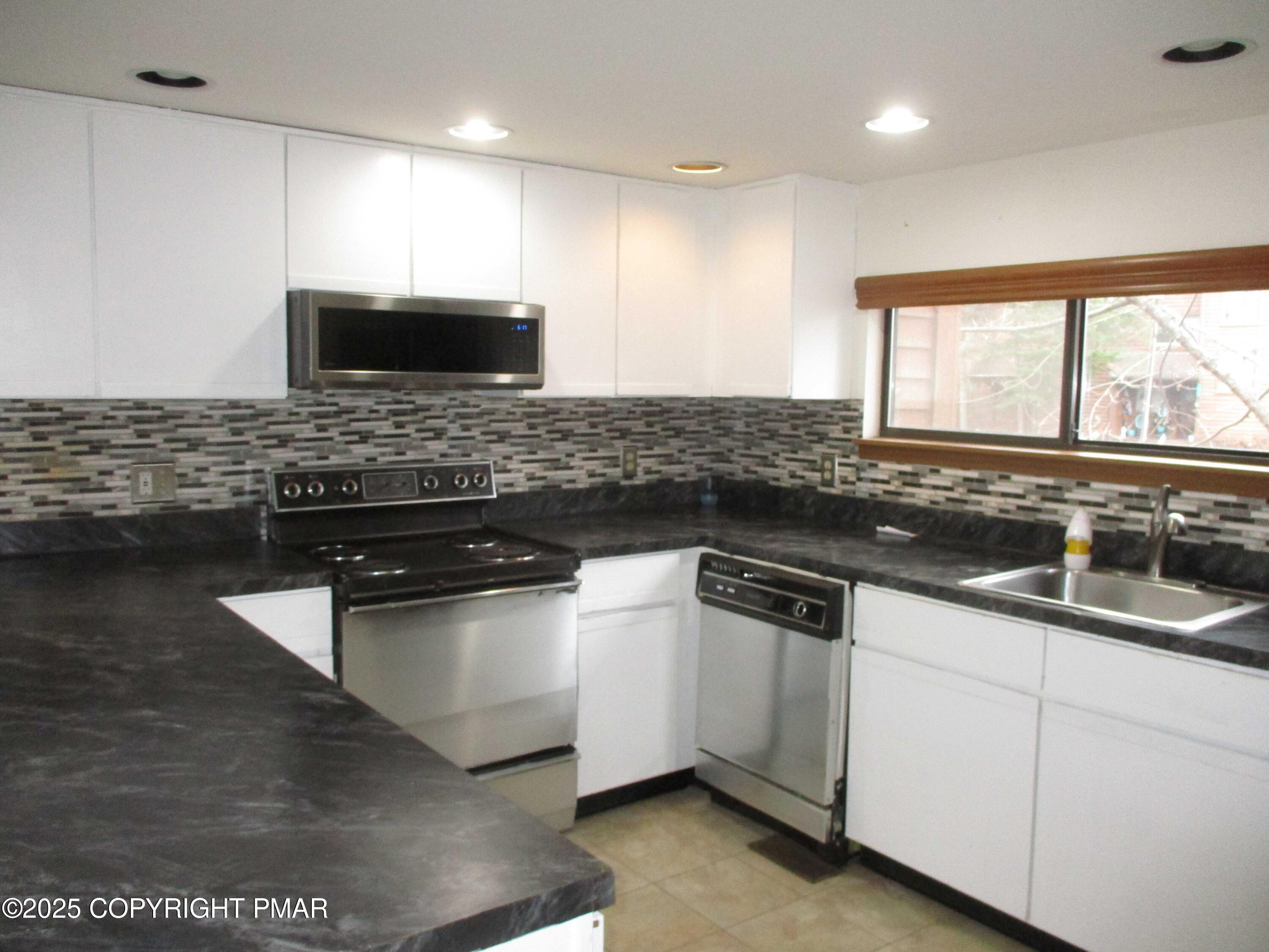 159 Stream Court Bushkill, PA 18324 - Photo 5 of 26 a kitchen with stainless steel appliances granite countertop a sink a stove and a microwave