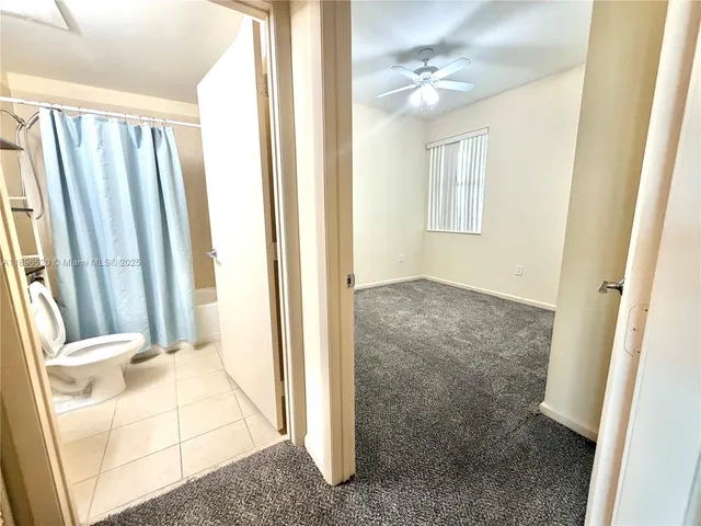an entryway to room with wooden floor and fan
