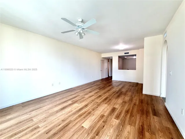 a view of a room with wooden floor and white walls