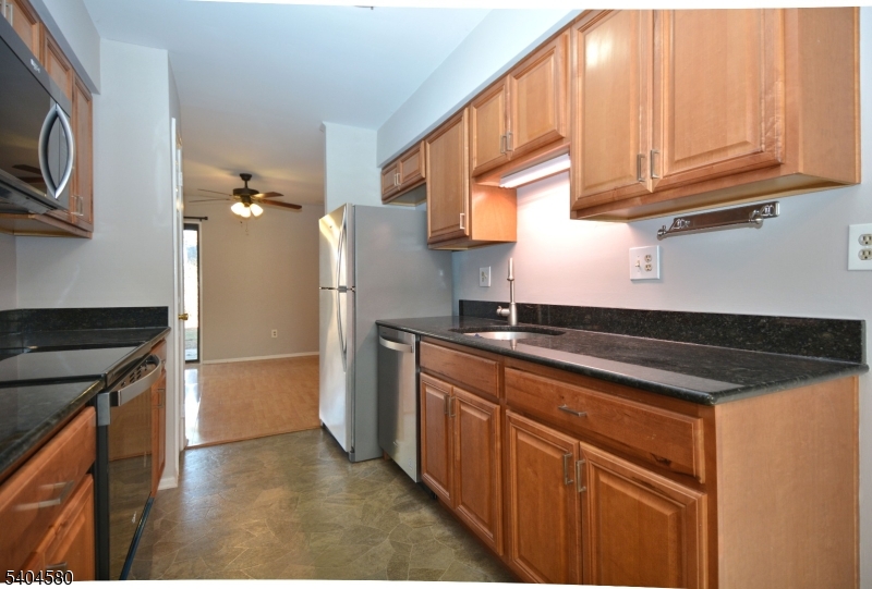 129 Hampton Court Somerset, NJ 08873 - Photo 5 of 25 a kitchen with granite countertop a refrigerator and a stove top oven