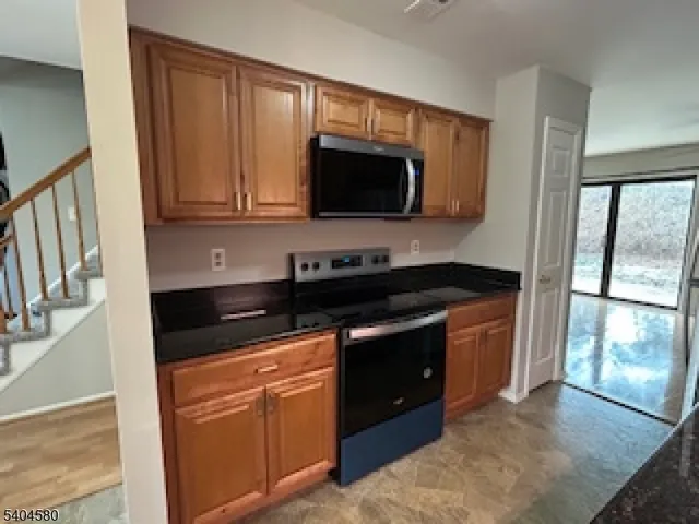 a kitchen with stainless steel appliances granite countertop a stove microwave and sink