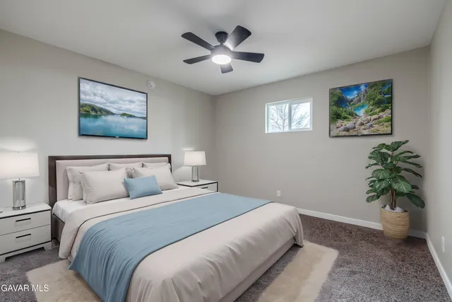 a bedroom with bed and a painting on the wall