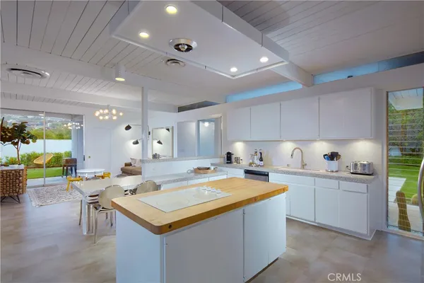 a kitchen with a stove a sink dishwasher and a refrigerator with wooden floor