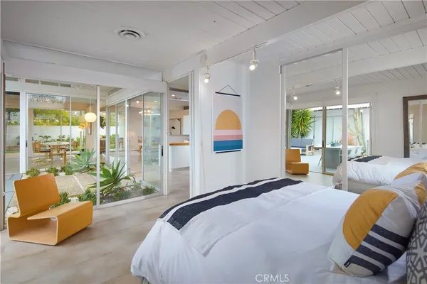 a bedroom with a bed and glass walk in closet