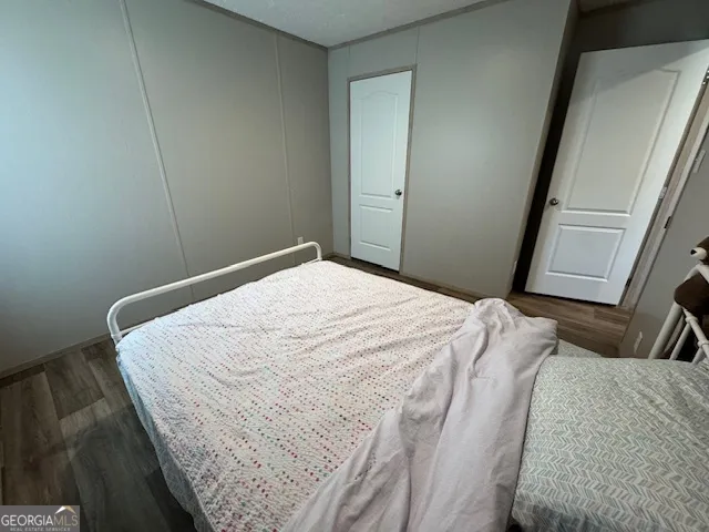 a bedroom with a bed and hardwood