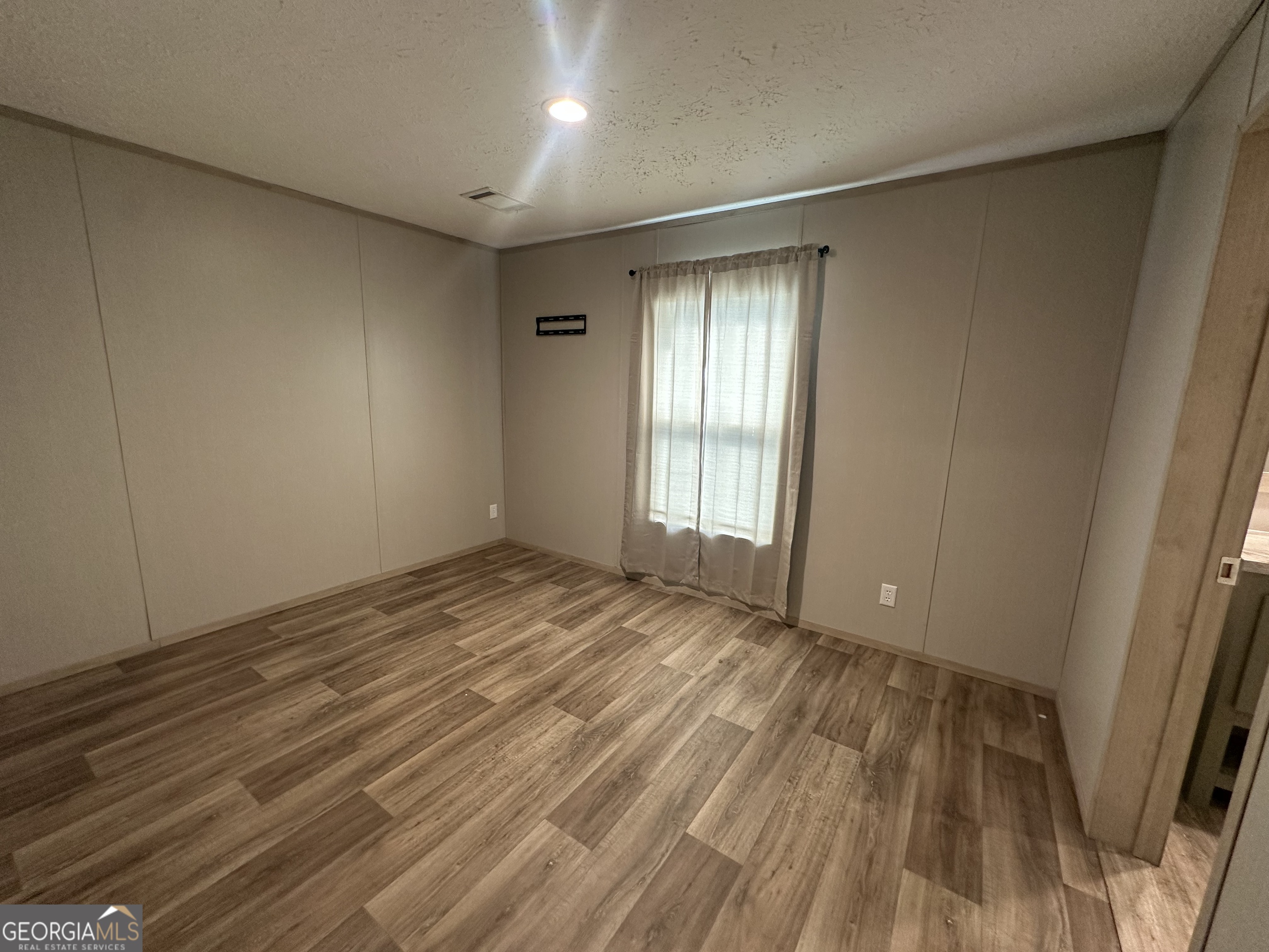 2470 Kitchen Road Dexter, GA 31019 - Photo 26 of 56 an empty room with wooden floor and windows