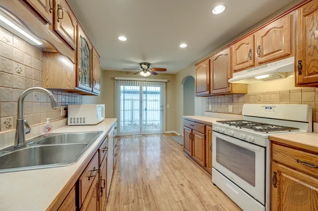 a kitchen with stainless steel appliances granite countertop a lot of counter space and wooden floors