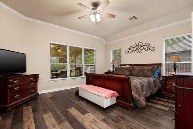 a spacious bedroom with a bed and a flat screen television