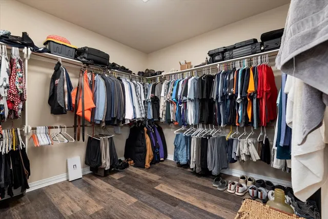 a view of walk in closet with clothes and shoes