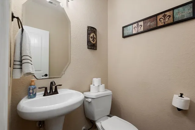 a bathroom with a sink mirror and toilet