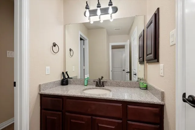 a bathroom with a granite countertop sink and a mirror