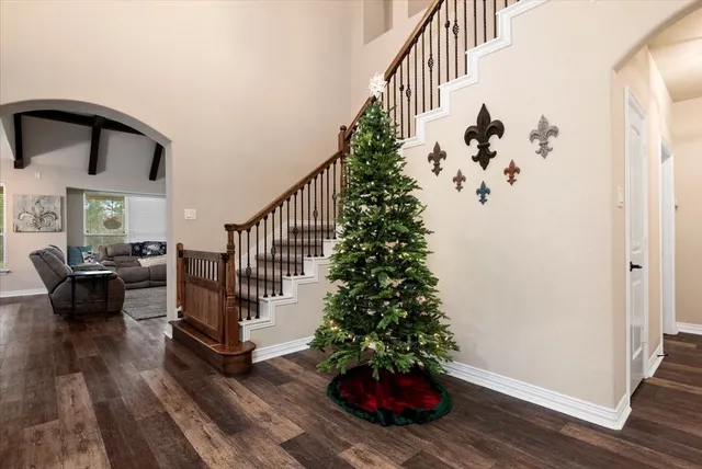 a view of a hallway with wooden floor and stairs