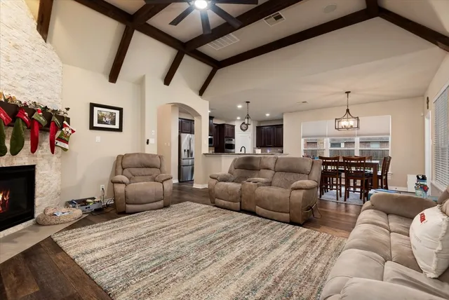 a living room with furniture a fireplace and a chandelier