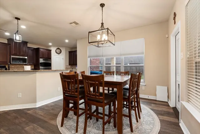 a view of a dining room with furniture wooden floor and chandelier