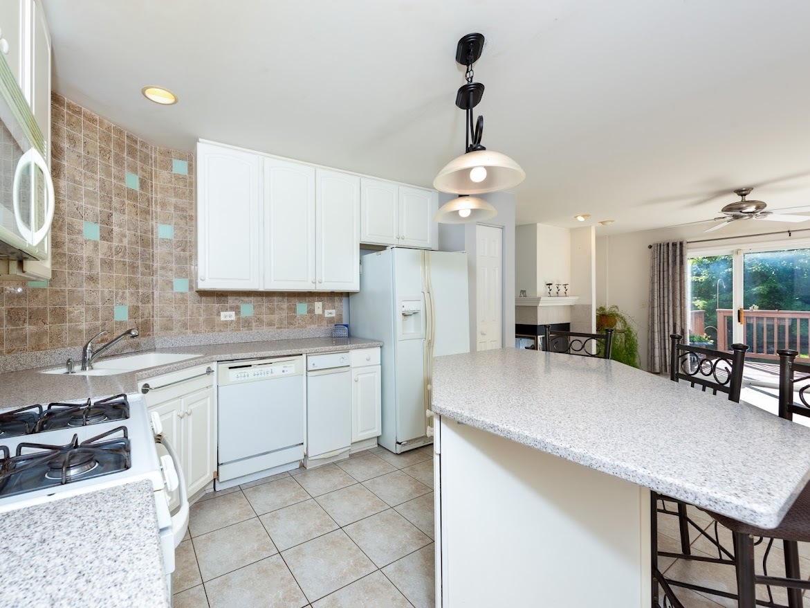 3110 Crystal Rock Road Naperville, IL 60564 - Photo 11 of 27 a kitchen with stainless steel appliances a table chairs and chandelier