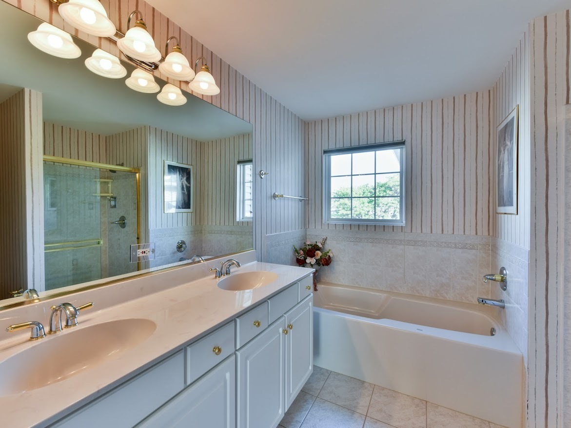 3110 Crystal Rock Road Naperville, IL 60564 - Photo 20 of 27 a bathroom with a tub a double vanity sink and a mirror