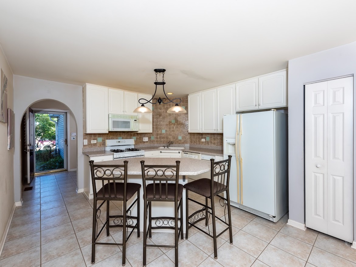 3110 Crystal Rock Road Naperville, IL 60564 - Photo 9 of 27 a dining area with a table chairs and refrigerator