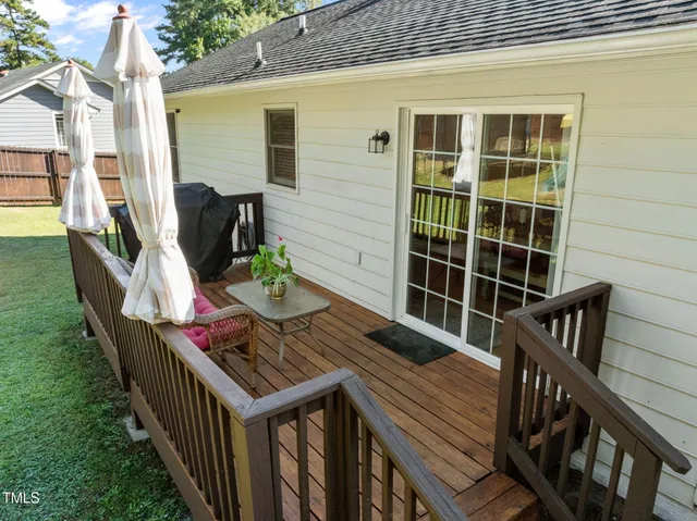 a view of balcony with two chairs and wooden fence
