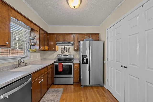 a kitchen with stainless steel appliances granite countertop a refrigerator and a sink