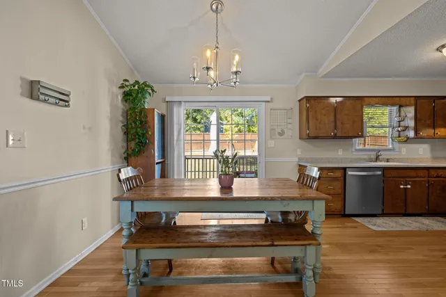 a kitchen with a chandelier and wooden floors