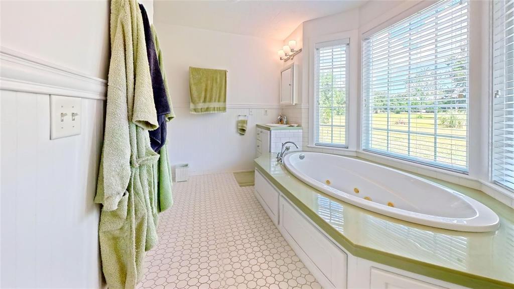 7390 South Mc Alpin Road McAlpin, FL 32062 - Photo 25 of 53 a bathroom with a tub sink and a large mirror