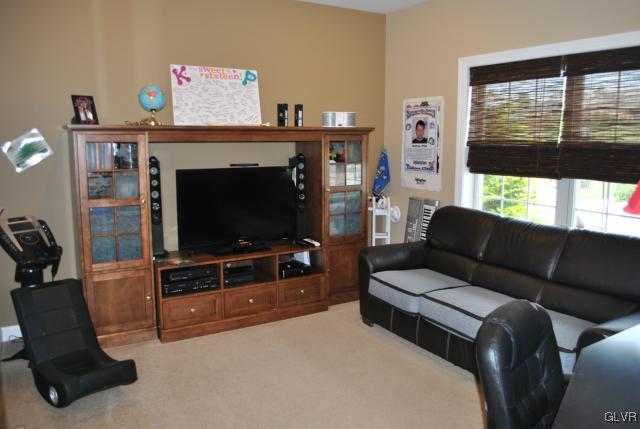 109 Fox Ridge Nazareth, PA 18064 - Photo 17 of 33 a living room with furniture a flat screen tv and a floor to ceiling window